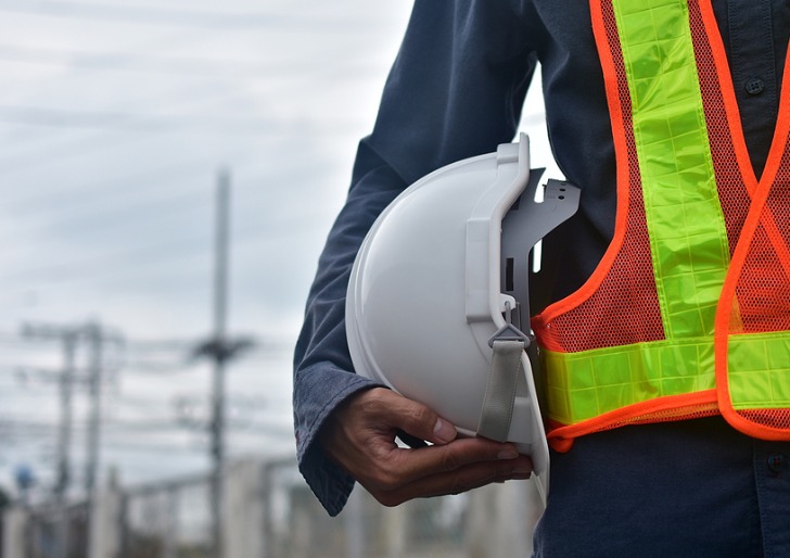 Close up of a man holding a hard hat